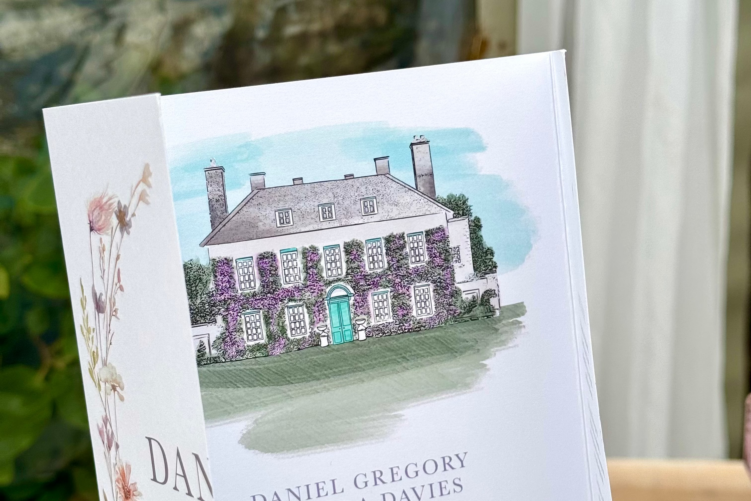 folded wedding invitation with watercolour venue painting of wedding venue
